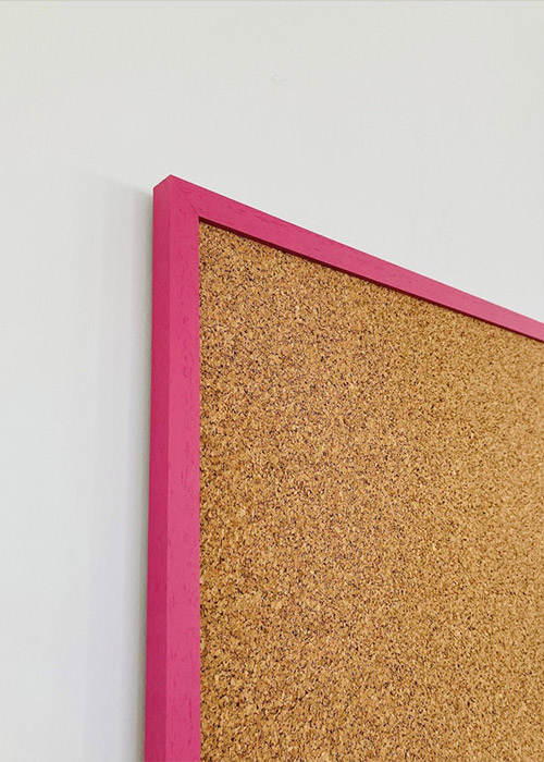 Bright pink framed cork pin board