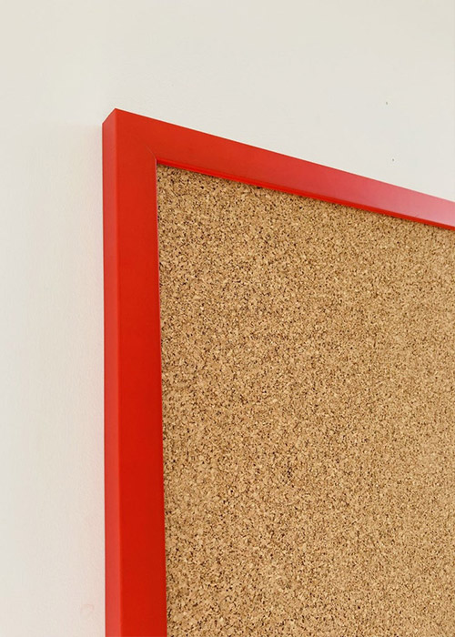 Red framed cork pin board