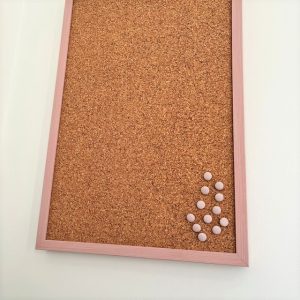 Pale pink notice board on wall
